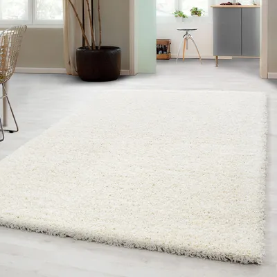 A fluffy white rug is laid out on a light-colored floor in a room with modern furniture and decor.