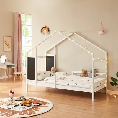 A child's bedroom with a house-shaped bed, toys, and decorations.