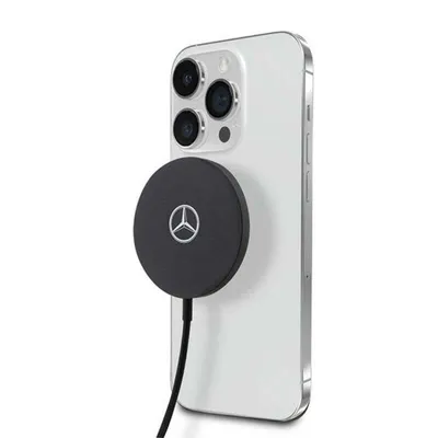 A white iPhone with a black wireless charger attached to the back.