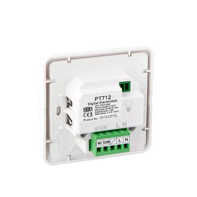 The back of a white digital thermostat with green terminal blocks.