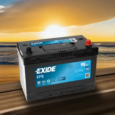 A car battery is placed on a wooden surface with a beach and sunset in the background.