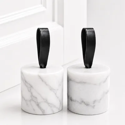 Immagine prodotto di Set di 2 fermaporta in marmo – Bianco – Pesanti fermaporta con anello – Marmo naturale – Diametro 8,5 x 9 cm – Peso di 1,2 kg ciascuno, Immagine generata dall'IA