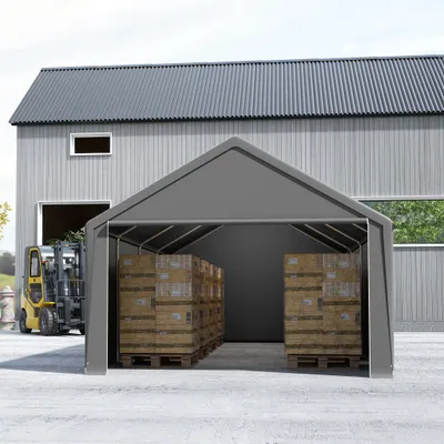 A grey storage tent with boxes inside, next to a building and a forklift.