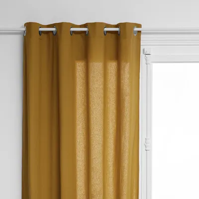 A close-up view of a caramel brown curtain hanging from a white curtain rod.
