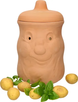 A terracotta potato storage pot with a face design, surrounded by potatoes and basil leaves.