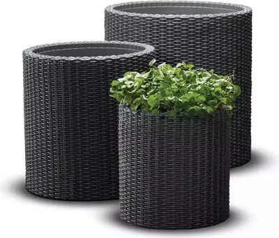Three dark brown woven planters of different sizes, with one containing green plants.