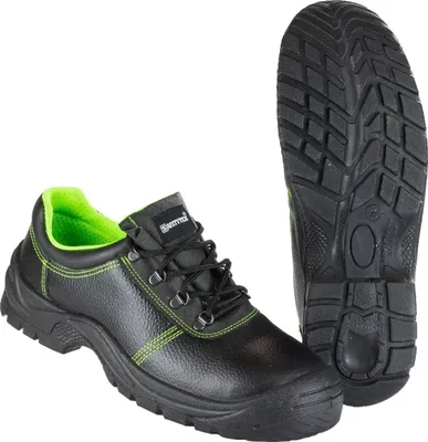 A pair of black safety shoes with green accents and a separate sole are displayed against a white background.