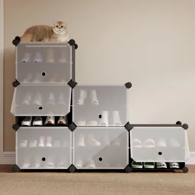 A cat is sitting on top of a modular shoe rack unit.