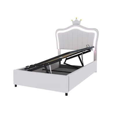 A white upholstered bed frame with a crown-shaped headboard featuring LED lighting, shown with its hydraulic lift mechanism exposed.