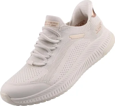 Das Bild zeigt einen weißen Freizeitschuh der von der Seite betrachtet wird. Der Schuh hat eine sportliche Form und eine rutschfeste Sohle.
