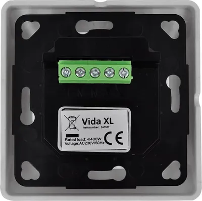 The back of a white electrical wall plate with a black mounting bracket and a green terminal block. A label with product information is visible.