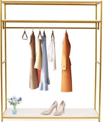 A gold clothing rack with shelves displaying various clothing items, shoes, and a small vase of flowers.
