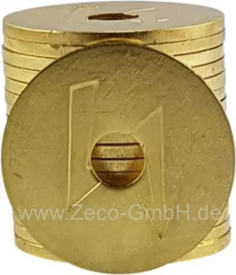 A stack of gold-colored tokens with a hole in the center, one token is in the foreground.
