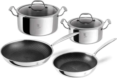 A set of stainless steel pots and pans with glass lids, arranged on a white background.