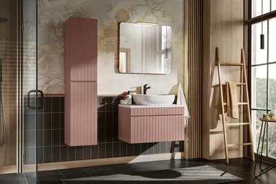 A modern bathroom with a rose-colored vanity, sink, mirror, and storage cabinet, complemented by wooden accents and a large window.