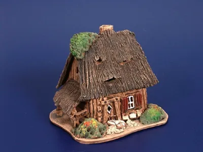 Die Magdhütte ist detailliert gestaltet mit strohgedeckten Dach. Der Stil des Hauses wirkt rustikal.