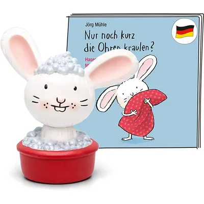 A Tonies Hörfigur of a bunny in a red tub, next to a children's book.