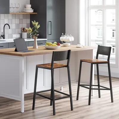 A modern kitchen island with two bar stools in front of it, with a window in the background.