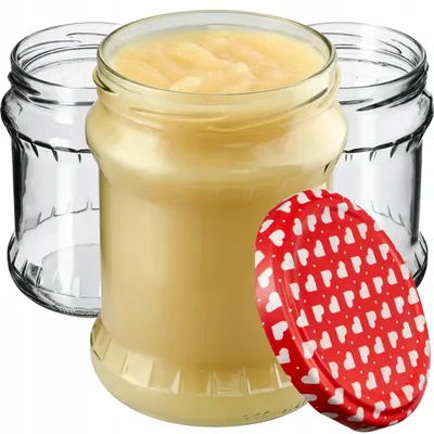 Three glass jars, one filled with a yellow substance, and a red lid with white hearts are arranged on a white background.