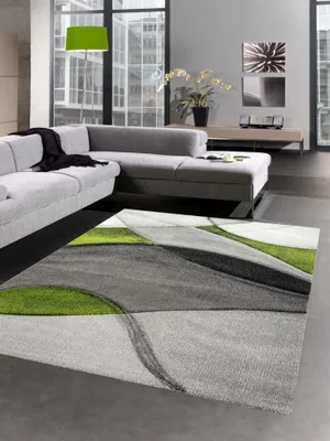 A modern living room with a sectional sofa and a geometric rug.