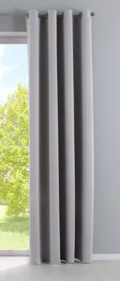 A gray curtain hanging in front of a window with trees visible outside.