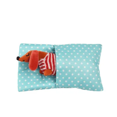 A plush dachshund toy is tucked into a polka-dotted pillowcase.