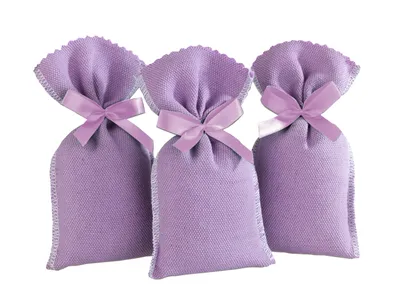 Three lavender-colored fabric sachets tied with a ribbon, arranged in a row against a white background.
