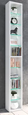 A tall, narrow white shelving unit filled with decorative items and books, set against a textured gray wall.