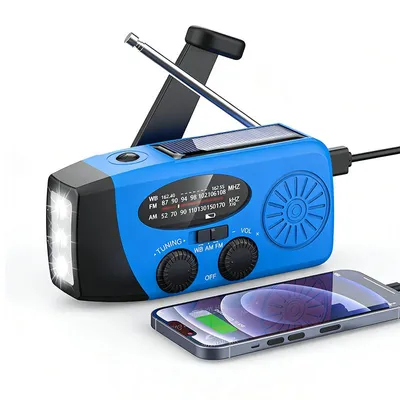 A blue emergency radio with a solar panel, LED flashlight, and antenna, shown next to a smartphone that is charging from the radio.