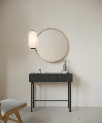 A console table with a drawer, a round mirror, a pendant light, and a chair in a room.