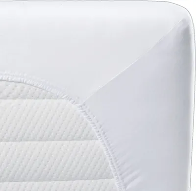 A close-up view of a white fitted sheet or mattress protector corner, showing the elasticized edge and the quilted texture of the mattress underneath.