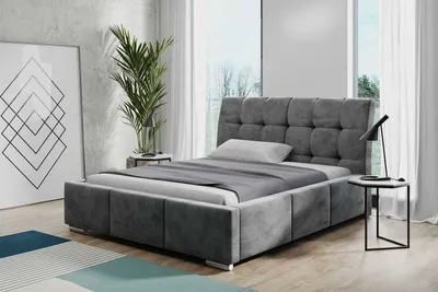 A modern bedroom with a gray upholstered bed.