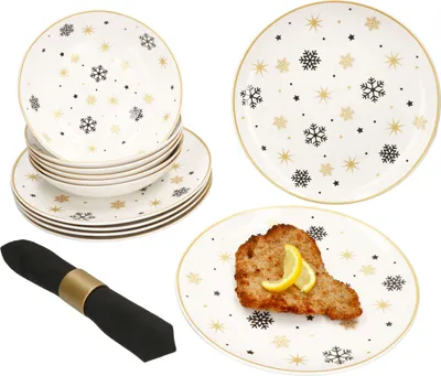 A set of plates and bowls with a snowflake design, along with a napkin and a plate with food.