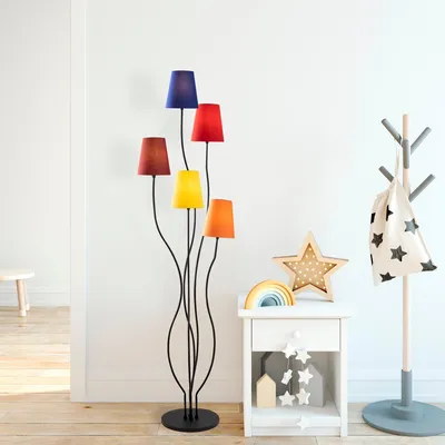A colorful floor lamp with multiple shades stands in a room next to a nightstand and a coat rack.