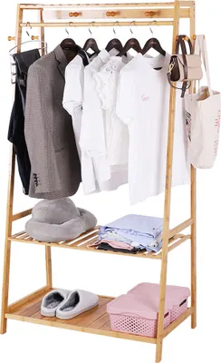 A bamboo clothing rack with clothes and accessories displayed on it.