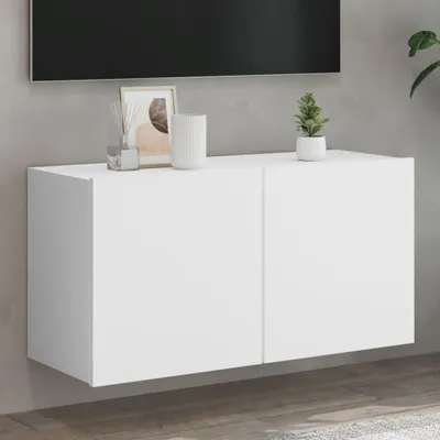 A white wall-mounted TV cabinet with two doors, shown in a living room setting.