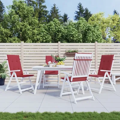 An outdoor patio scene with a white dining set and red cushions.