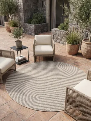 Runder Teppich mit geometrischem Muster in einem hellen Wohnzimmer mit cremefarbenem Sofa._#sku_BARKDESERT1201201301BEIGE-BARKDESERT1601601301BEIGE-BARKDESERT2002001301BEIGE-BARKDESERT80801301BEIGE#