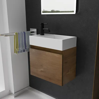 A modern bathroom vanity with a white sink and a wooden cabinet, mounted on a dark textured wall.