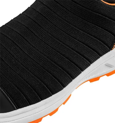 A close-up view of the side of a black shoe with orange accents on the sole.