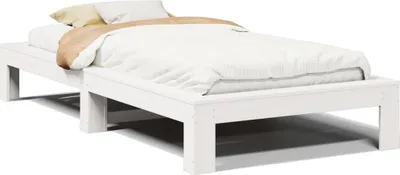 A white wooden bed frame with white bedding and a tan pillow.