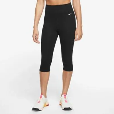 A person wearing black Nike capri leggings and white sneakers, shown from the waist down against a white background.