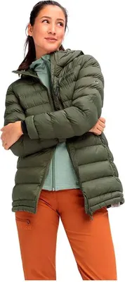 A woman wearing a green puffer coat and orange pants.