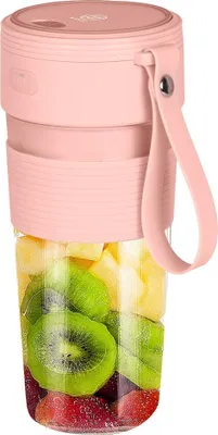 A pink portable blender filled with fruit.