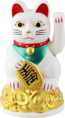 A white Maneki-neko (lucky cat) figurine with red ears and collar, holding a gold ingot, sitting on a pile of gold coins.