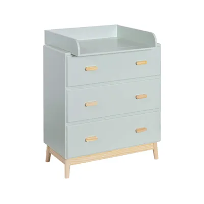 A light green changing table with wooden accents and three drawers, shown from a three-quarter angle against a white background.