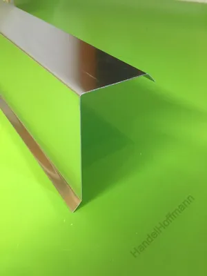A metallic corner piece is placed on a bright green surface.
