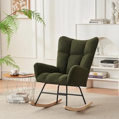 A green rocking chair is placed in a living room setting with a side table and a plant.