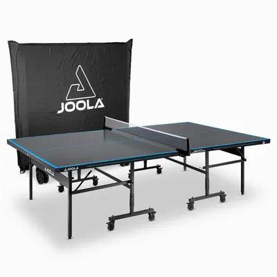 A JOOLA outdoor table tennis table with a protective cover behind it, presented on a white background.