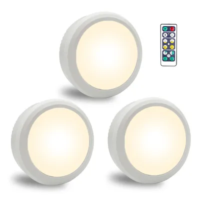 Three white LED puck lights and a remote control are displayed against a white background.